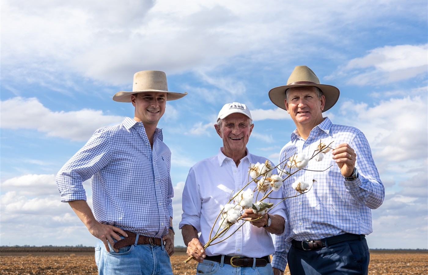 Three generations of Goondiwindi Cotton family members standing in a cotton field.