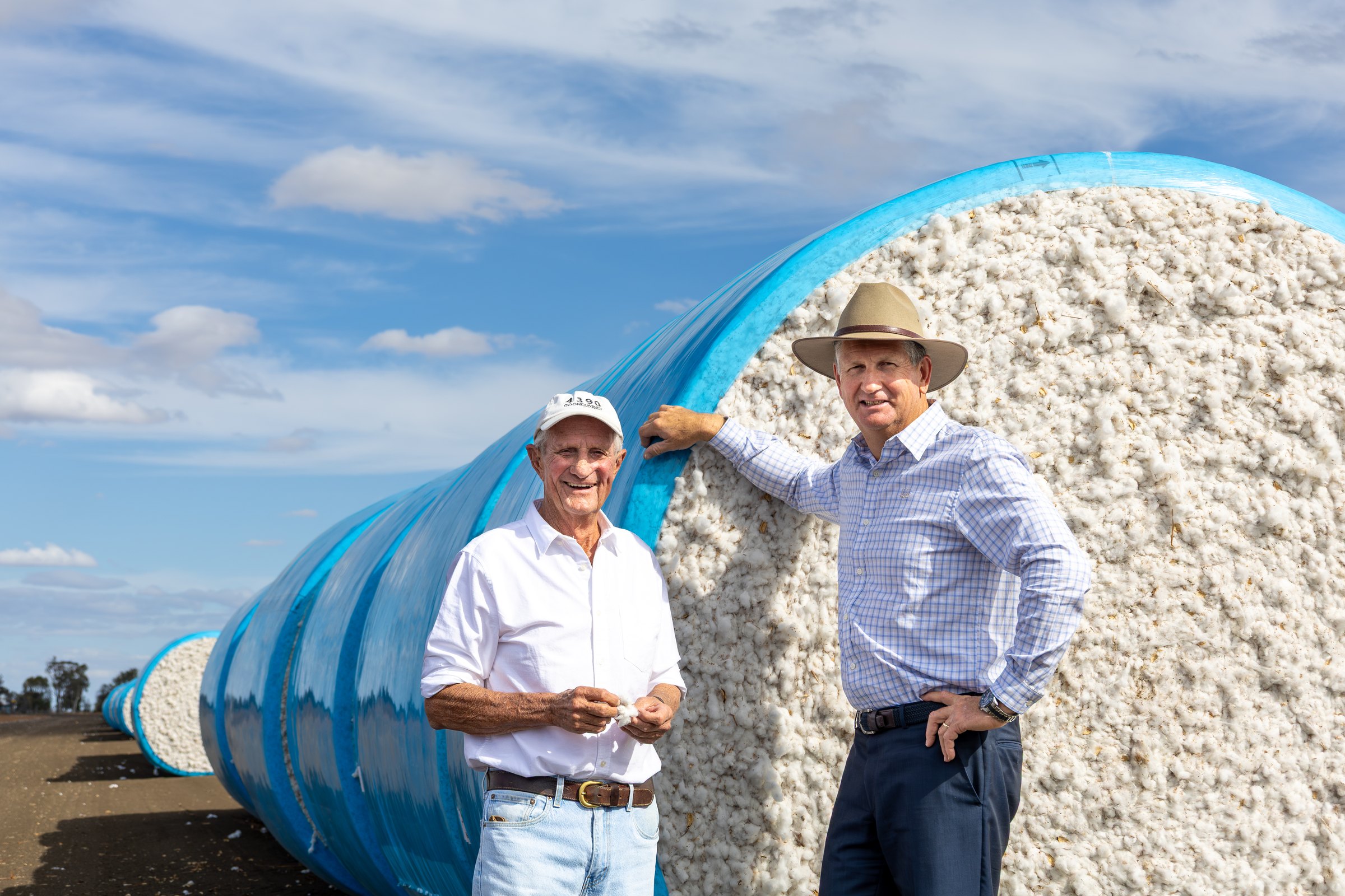 Goondiwindi Cotton family members standing beside cotton bales.